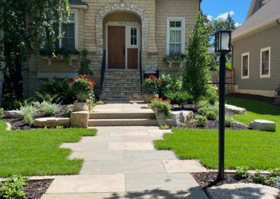 City Cottage in Minneapolis, MN with an Irregular Bluestone Walkway and Outcroppings to Front Door