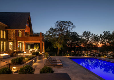 Pleasant Lake Home at Night with Outdoor Lighting the Pool and Patios