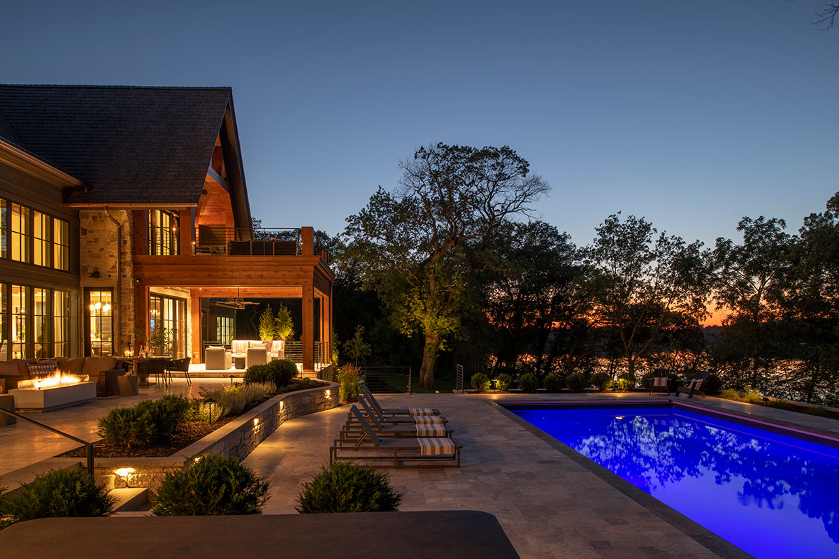 Pleasant Lake Home at Night with Outdoor Lighting the Pool and Patios