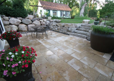 Sunken Limestone Patio from Lower Level Walkout Surrounded by Boulder and Limestone Retaining Walls